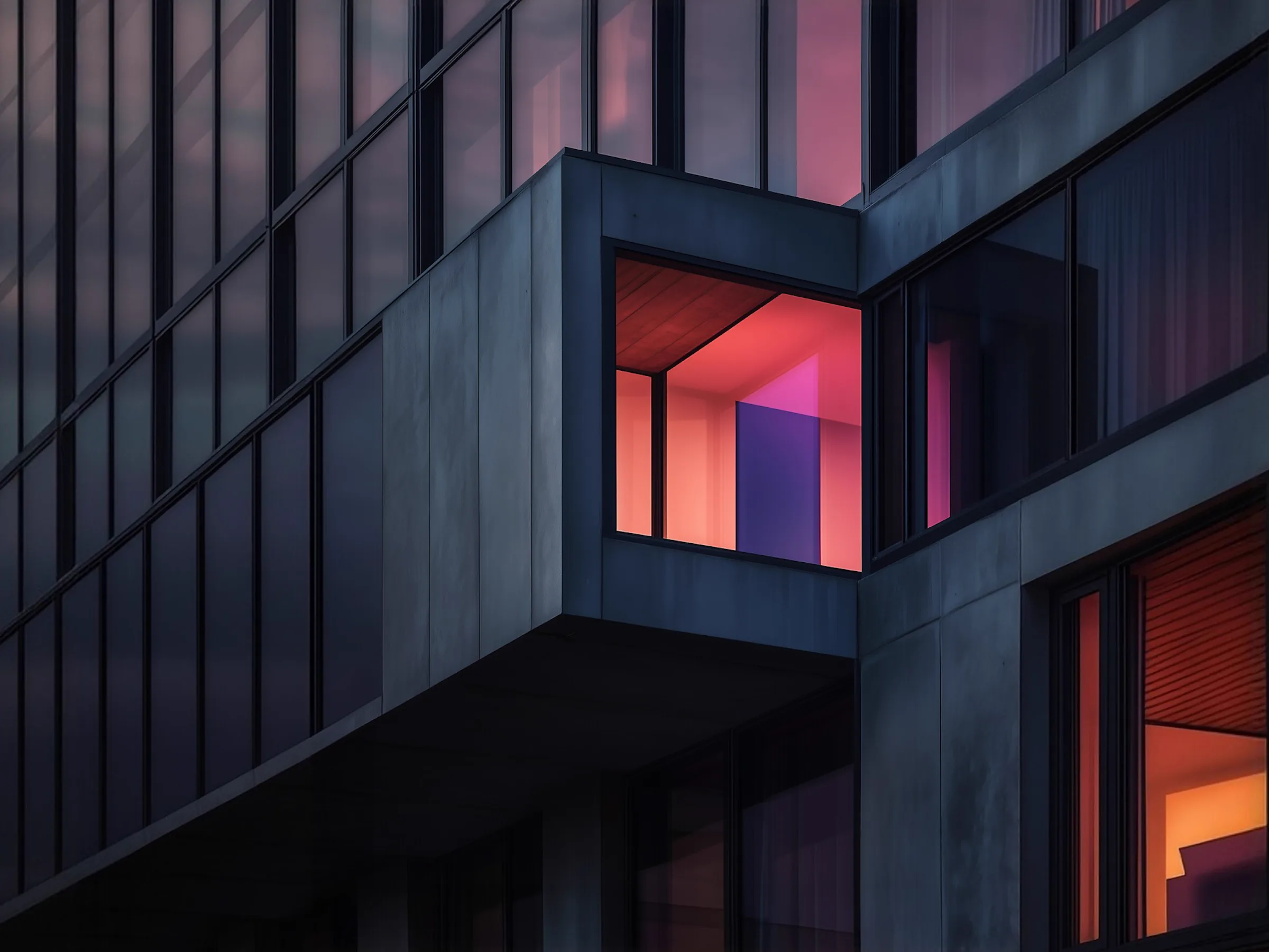 A glass-fronted building lit from inside at dusk, beside our twelve years of experience
